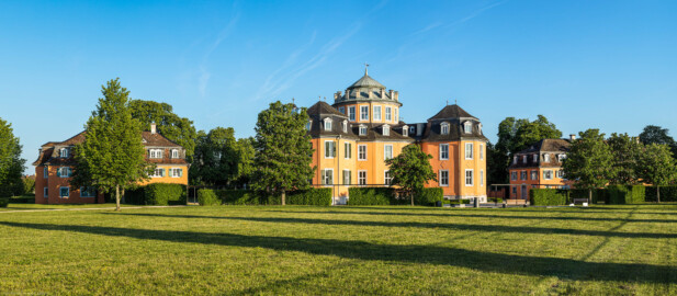 Waghäusel - Eremitage - Von Außen / Von Nordwesten - Blick auf das Gesamt-Ensemble: in der Mitte der Zentralbau, links der nordöstliche und rechts der südwestliche Kavalierspavillon (aufgenommen im Mai 2019, am frühen Abend)