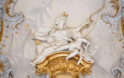 Schloss Bruchsal - Hauptbau / Corps de Logis - Beletage - Marmorsaal / Kaisersaal - Oberhalb der Tür zum Balkon - Von Osten - Blick vom Durchgang zum Kuppelsaal nach Westen auf eine weibliche Figur und eine Putte (Stuckaturen ursprünglich von Johann Michael Feichtmayr) (aufgenommen im Mai 2019, am Nachmittag) Schloss Bruchsal - Hauptbau / Corps de Logis - Beletage - Marmorsaal / Kaisersaal - Oberhalb der Tür zum Balkon - Von Osten - Blick vom Durchgang zum Kuppelsaal nach Westen auf eine weibliche Figur und eine Putte (Stuckaturen ursprünglich von Johann Michael Feichtmayr) (aufgenommen im Mai 2019, am Nachmittag)