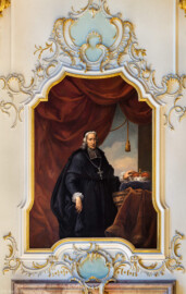 Schloss Bruchsal - Hauptbau / Corps de Logis - Beletage - Fürstensaal - Südseite, Osten - Blick von Norden auf das Portrait von Heinrich Hartard von Rollingen (1711 bis 1719 Fürstbischof von Speyer) (ursprünglich gemalt von Johannes Zick, um 1753; rekonstruiert von Walter Maschke, 1973 bis 1974) (aufgenommen im Juni 2019, am späten Vormittag)