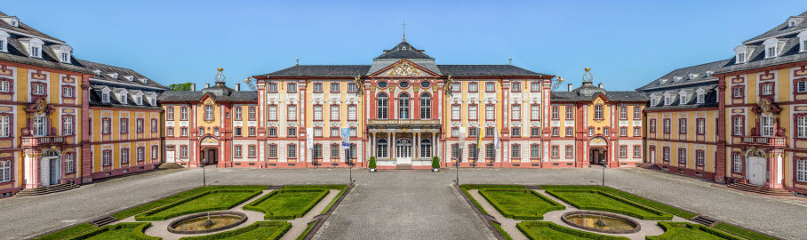 Schloss Bruchsal - Hauptbau / Corps de Logis - Von Außen / Von Osten / Hofseite - Blick vom Balkon des Torwachtgebäudes auf den Ehrenhof, den Hauptbau / das Corps de Logis (Mitte), die Verbindungsbauten (links und rechts) sowie den Kirchenflügel / die Hofkirche / St. Damian und Hugo (ganz links) und den Kammerflügel / das Amtsgericht (ganz rechts) (aufgenommen im Juni 2019, am späten Vormittag) Schloss Bruchsal - Hauptbau / Corps de Logis - Von Außen / Von Osten / Hofseite - Blick vom Balkon des Torwachtgebäudes auf den Ehrenhof, den Hauptbau / das Corps de Logis (Mitte), die Verbindungsbauten (links und rechts) sowie den Kirchenflügel / die Hofkirche / St. Damian und Hugo (ganz links) und den Kammerflügel / das Amtsgericht (ganz rechts) (aufgenommen im Juni 2019, am späten Vormittag)