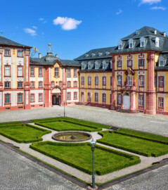 Schloss Bruchsal - Nördlicher Verbindungsbau / Hauptbau / Corps de Logis / Kammerflügel / Amtsgericht - Von Außen - Hofseite - Von Südost  - Blick vom Balkon des Torwachtgebäudes auf den Ehrenhof, den Hauptbau / das Corps de Logis (links), den nördlichen Verbindungsbau (Mitte) sowie den Kammerflügel / das Amtsgericht (rechts) (aufgenommen im Juni 2019, am späten Vormittag)