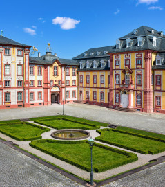 Schloss Bruchsal - Nördlicher Verbindungsbau / Hauptbau / Corps de Logis / Kammerflügel / Amtsgericht - Von Außen - Hofseite - Von Südost - Blick vom Balkon des Torwachtgebäudes auf den Ehrenhof, den Hauptbau / das Corps de Logis (links), den nördlichen Verbindungsbau (Mitte) sowie den Kammerflügel / das Amtsgericht (rechts) (aufgenommen im Juni 2019, am späten Vormittag) Schloss Bruchsal - Nördlicher Verbindungsbau / Hauptbau / Corps de Logis / Kammerflügel / Amtsgericht - Von Außen - Hofseite - Von Südost - Blick vom Balkon des Torwachtgebäudes auf den Ehrenhof, den Hauptbau / das Corps de Logis (links), den nördlichen Verbindungsbau (Mitte) sowie den Kammerflügel / das Amtsgericht (rechts) (aufgenommen im Juni 2019, am späten Vormittag)
