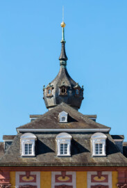 Schloss Bruchsal - Kirchenflügel / Hofkirche / St. Damian und Hugo - Von Norden / Hofseite - Blick vom Balkon des Kammerflügels / des Kammermusiksaals auf das Dach oberhalb des Mittelrisalits und auf die Zwiebelhaube des Kirchturms dahinter (aufgenommen im Juni 2019, am Vormittag)