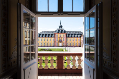Schloss Bruchsal - Kirchenflügel / Hofkirche / St. Damian und Hugo - Von Norden / Hofseite - Blick vom Balkon des Kammermusiksaals im Kammerflügel auf den Ehrenhof und den Kirchenflügel (aufgenommen im Juni 2019, um die Mittagszeit)