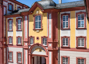 Schloss Bruchsal - Nördlicher Verbindungsbau - Von Nordost / Hofseite - Blick vom Balkon des Kammerflügels / des Kammermusiksaals auf den nördlichen Verbindungsbau (aufgenommen im Juni 2019, um die Mittagszeit) Schloss Bruchsal - Nördlicher Verbindungsbau - Von Nordost / Hofseite - Blick vom Balkon des Kammerflügels / des Kammermusiksaals auf den nördlichen Verbindungsbau (aufgenommen im Juni 2019, um die Mittagszeit)