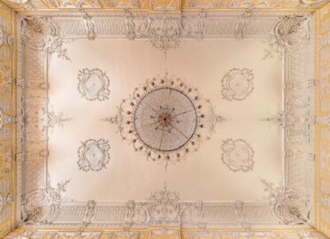 Schloss Bruchsal - Kammerflügel - Kammermusiksaal - Decke, Zentrum, links ist Süden - Blick vom Boden nach oben auf den Kronleuchter und die Decke (Saal ursprünglich gestaltet von Joachim Günther; heute genutzt von den Bruchsaler Schlosskonzerten) (aufgenommen im Juni 2019, am Nachmittag)