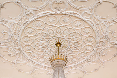 Schloss Bruchsal - Kammerflügel - Kammermusiksaal - Decke, Zentrum - Blick nach oben auf die Stuckdekoration oberhalb des Kronleuchters (Saal ursprünglich gestaltet von Joachim Günther; heute genutzt von den Bruchsaler Schlosskonzerten) (aufgenommen im Juni 2019, am Nachmittag)
