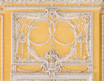 Schloss Bruchsal - Kammerflügel - Von innen - Kammermusiksaal - Westwand, Mitte, oben - Stuckdekorationen über dem mittleren Spiegel (Saal ursprünglich gestaltet von Joachim Günther; heute genutzt von den Bruchsaler Schlosskonzerten) (aufgenommen im Juli 2019, um die Mittagszeit)