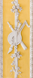 Schloss Bruchsal - Kammerflügel - Kammermusiksaal - Westwand, schmale Bahn rechts der südwestlichen Tür, weiter oben - Musikinstrumente als Stuckdekoration (Saal ursprünglich gestaltet von Joachim Günther; heute genutzt von den Bruchsaler Schlosskonzerten) (aufgenommen im Juli 2019, am Nachmittag)