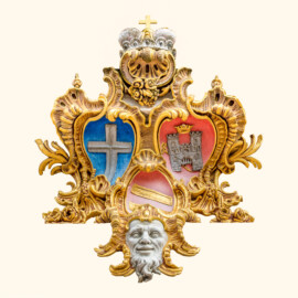 Schloss Bruchsal - Hauptbau / Corps de Logis - Mittelrisalit / Altan - Von Außen / Von Westen / Gartenseite - Allianzwappen, geschaffen von Joachim Günther - Unten: Wappen des Fürstbischofs Franz Christoph von Hutten zum Stolzenberg, links: Wappen des Hochstifts Speyer, rechts: Wappen der Propstei Weißenburg (aufgenommen im Juli 2019, am späten Nachmittag)