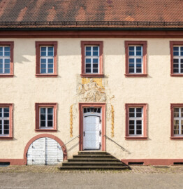 Schloss Bruchsal - Seminarbau / Pagerie - Von Außen / Von Norden - Blick auf den westlichen Eingang in den Seminarbau / die Pagerie sowie auf eine Allegorie (aufgenommen im August 2019, am  Vormittag)