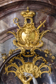 Bruchsal - Peterskirche / St. Peter - Südwestlicher Seitenaltar - Blick auf das Initialwappen von Franz Christoph von Hutten zum Stolzenberg, darunter eine Baumkrone und die Hand des Hl. Sebastians (Altar geschaffen von Johann Michael Feuchtmayer, 1754-1756; Sebastian-Plastik gefertigt von Joachim Günther) (aufgenommen im August 2019, am frühen Nachmittag)