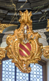 Bruchsal - Peterskirche / St. Peter - Hochaltar, oben, rechts - Blick auf das Familienwappen von Franz Christoph von Hutten zum Stolzenberg, mit Helm und "Reußenmännchen" (Altar entworfen von Balthasar Neumann und Johann Wolfgang van der Auwera, vor 1747) (aufgenommen im September 2019, am späten Vormittag)