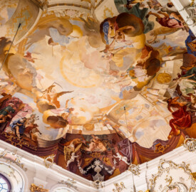 Schloss Bruchsal - Hauptbau / Corps de Logis - Beletage - Fürstensaal - Decke, Südostecke - Ausschnitt aus der südöstlichen Zone - Unten, Mitte: Darstellung des Weinbaus, ein wichtiger Wirtschaftszweig Bruchsals; links: Darstellung der Vier Jahreszeiten und der Vier Lebensalter als Musikkapelle; rechts: Darstellung der Jagd, ein wichtiger Wirtschaftszweig Bruchsals; oben: der "himmlische Bereich" mit Darstellungen griechisch-römischer Götter und Allegorien (Deckenfresko urspünglich gemalt 1751 von Johannes Zick, originalgetreu rekonstruiert 1966 bis 1969 von Wolfram Köberl) (aufgenommen im Dezember 2019, am frühen Nachmittag)
