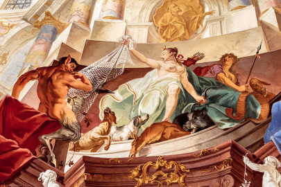 Schloss Bruchsal - Hauptbau / Corps de Logis - Beletage - Fürstensaal - Decke, untere Zone, Südwestecke - Ausschnitt aus der südwestlichen äußeren Zone - Darstellung der Jagd, ein wichtiger Wirtschaftszweig Bruchsals - Mittig (Frau mit Bogen und Köcher): Darstellung der griechischen / römischen Jagdgöttin Artemis / Diana, auf dem Kopf eine Mondsichel (als Göttin des Mondes); links (mannartige Figur); ein Faun, halb Mensch, halb Bock, ein Waldwesen, Begleiter der Jagdgöttin (Deckenfresko urspünglich gemalt 1751 von Johannes Zick, originalgetreu rekonstruiert 1966 bis 1969 von Wolfram Köberl) (aufgenommen im Januar 2020, am späten Vormittag) Schloss Bruchsal - Hauptbau / Corps de Logis - Beletage - Fürstensaal - Decke, untere Zone, Südwestecke - Ausschnitt aus der südwestlichen äußeren Zone - Darstellung der Jagd, ein wichtiger Wirtschaftszweig Bruchsals - Mittig (Frau mit Bogen und Köcher): Darstellung der griechischen / römischen Jagdgöttin Artemis / Diana, auf dem Kopf eine Mondsichel (als Göttin des Mondes); links (mannartige Figur); ein Faun, halb Mensch, halb Bock, ein Waldwesen, Begleiter der Jagdgöttin (Deckenfresko urspünglich gemalt 1751 von Johannes Zick, originalgetreu rekonstruiert 1966 bis 1969 von Wolfram Köberl) (aufgenommen im Januar 2020, am späten Vormittag)