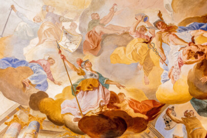Schloss Bruchsal - Hauptbau / Corps de Logis - Beletage - Fürstensaal - Decke, innere Zone, südwestlich des Zentrums der Decke - Oben ganz links: Darstellung einer Frau mit Anker in der Hand als Allegorie für die Hoffnung; rechts davon: Darstellung einer gekrönten Frau als Allegorie für Speyer; rechts davon: eine Frau hält einen Plan mit den Residenzstädten der Bischöfe von Speyer (Speyer, Udenheim/Philippsburg, Bruchsal); oben Mitte: Darstellung einer Frau mit einem Fürstenhut (als Symbol der fürstlichen Würde, neben der geistlichen Bischofswürde des Fürstbischofs) in den ausgestreckten Händen; oben rechts der Mitte: ein Genius, eine Mitra (als Symbol für die geistliche Würde) über Hermes haltend; oben ganz rechts: Darstellung des Götterboten Hermes (mit Flügeln an Helm und Füßen), in der Hand den Hermesstab (ein Stab  mit zwei Flügeln, umschlungen von zwei Schlangen); rechts darunter: Darstelllung des besiegten Ungeheuers Argos, dessen 100 Augen auf einem Tuch abgebildet sind; unten mittig: Darstellung der Athene, Göttin der Künste und der Kriegskunst, mit Federhelm und Lanze; rechts unterhalb davon: ein Genius, Athenes Schild haltend (Deckenfresko urspünglich gemalt 1751 von Johannes Zick, originalgetreu rekonstruiert 1966 bis 1969 von Wolfram Köberl) (aufgenommen im Februar 2020, um die Mittagszeit)