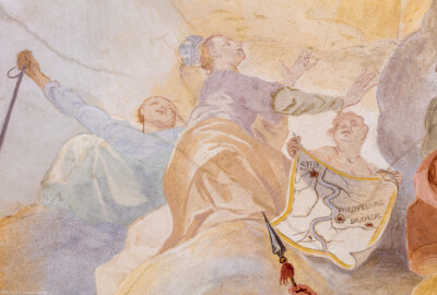 Schloss Bruchsal - Hauptbau / Corps de Logis - Beletage - Fürstensaal - Decke, innere Zone, südwestlich des Zentrums der Decke - Links: Darstellung einer Frau mit Anker in der Hand als Allegorie für die Hoffnung; Mitte: Darstellung einer gekrönten Frau als Allegorie für Speyer; rechts: eine Frau hält einen Plan mit den Residenzstädten der Bischöfe von Speyer (Speyer, Udenheim/Philippsburg, Bruchsal) (Deckenfresko urspünglich gemalt 1751 von Johannes Zick, originalgetreu rekonstruiert 1966 bis 1969 von Wolfram Köberl) (aufgenommen im Februar 2020, am frühen Nachmittag)