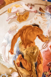 Schloss Bruchsal - Hauptbau / Corps de Logis - Beletage - Marmorsaal / Kaisersaal - Deckenfresko, äußere Zone, südöstlich des Zentrums der Decke - Unten: Darstellung des Herakles / Hercules; oben: ein Putto stutzt die Flügel von Fortuna (Deckenfresko urspünglich gemalt 1754 von Johannes Zick, originalgetreu rekonstruiert 1971 bis 1974 von Wolfram Köberl; Stuck urspünglich von Johann Michael Feuchtmayer dem Jüngeren, rekonstruiert 1962 bis 1969 von Jakob und Josef Schnitzer) (aufgenommen im Februar 2020, am Nachmittag)