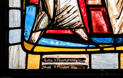 Waghäusel - Wallfahrtskirche - Von innen - Alter Chor - Nordostwand  - Rechtes / östliches Fenster - Von Südwesten - Fenster "Die Verherrlichung Christi und Mariens" - Ausschnitt mit Signatur (linke Bahn, unterstes Feld) aus dem Chorfenster (Entwurf von Valentin Peter Feuerstein, Neckarsteinach, 1960; Ausführung von der Glaswerkstatt Meysen, Heidelberg) (aufgenommen im Februar 2020, am Nachmittag)