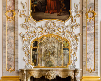 Schloss Bruchsal - Hauptbau / Corps de Logis - Beletage - Fürstensaal - Nordseite, Mitte - Blick auf den reichen Rocaille-Schmuck um den Spiegel, den oberen Teil des Kamins, den unteren Teil des Portraits von Damian Hugo Philipp von Schönborn-Buchheim und die Pilaster auf beiden Seiten (aufgenommen im März 2020, am Nachmittag)
