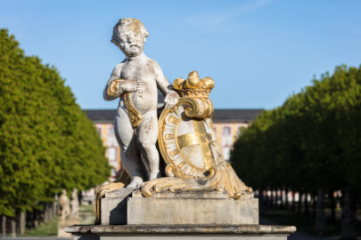 Schloss Bruchsal - Garten - Westeingang / Haltestelle Schlossgarten - Nördlicher Torpfosten - Von Westen - Blick auf einen Putto und eine Kartusche mit Bischofshut und Wappen des Hochstifts Speyer (aufgenommen im April 2020, am späten Nachmittag)