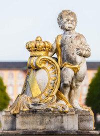 Schloss Bruchsal - Garten - Westeingang / Haltestelle Schlossgarten - Südlicher Torpfosten - Von Westen - Blick auf einen Putto und eine Kartusche mit Krone und dem Wappen Badens (aufgenommen im April 2020, am späten Nachmittag)