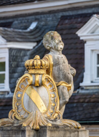 Schloss Bruchsal - Garten - Westeingang / Haltestelle Schlossgarten - Südlicher Torpfosten - Von Nordwesten - Blick auf einen Putto und eine Kartusche mit Krone und dem Wappen Badens (aufgenommen im April 2020, am späten Nachmittag)