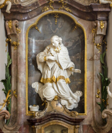 Bruchsal - Peterskirche / St. Peter - Westliches Querschiff, Südwand - Nepomukaltar - Von Norden - Blick auf die Statue des Hl. Nepomuk (Johannes von Nepomuk, 1350-1393, böhmischer Priester und Märtyrer, Brückenheiliger und Patron des Beichtgeheimnisses; Nepomuk-Plastik gefertigt von Joachim Günther) (aufgenommen im April 2020, um die Mittagszeit)