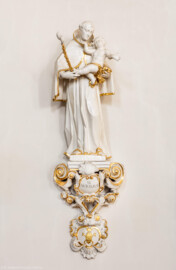 Bruchsal - Peterskirche / St. Peter - Längsschiff / Ostwand - Von Westen - Blick auf eine Figur eines Zunftheiligen, St. Antonius von Padua (* um 1195, Heiliger und Kirchenlehrer, portugiesischer Ordenspriester des Franziskanerordens) und dem Zunftschild der Seiler und Gärtner (aufgenommen im April 2020, am Nachmittag)