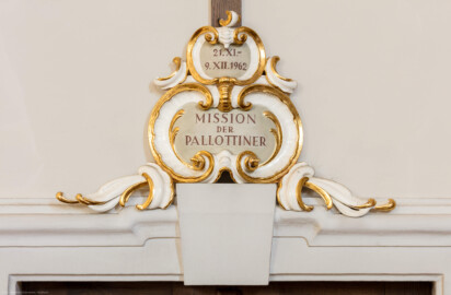 Bruchsal - Peterskirche / St. Peter - Längsschiff / Westwand - Von Osten - Blick auf eine Gedenkinschrift einer Mission der Pallottiner (der Gesellschaft des katholischen Apostolates) über der Tür zum westlichen Oratorium (aufgenommen im April 2020, am späten Nachmittag) Bruchsal - Peterskirche / St. Peter - Längsschiff / Westwand - Von Osten - Blick auf eine Gedenkinschrift einer Mission der Pallottiner (der Gesellschaft des katholischen Apostolates) über der Tür zum westlichen Oratorium (aufgenommen im April 2020, am späten Nachmittag)
