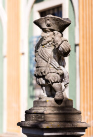 Schloss Bruchsal - Südliche Orangerie / Kavaliersbau, Westseite - Von Südwesten - Zwerg auf der Balustrade (rechts/südlich der Mitte) (gehauen von Joachim Günther) (aufgenommen im Mai 2020, am Nachmittag)