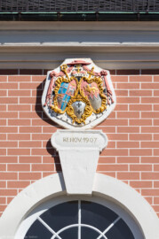 Schloss Bruchsal - Kanzleibau / Amtsgericht - Von Westen - Blick vom Torwachtgebäude auf die Fassade des Kanzleibaus mit dem Prunkwappen von Damian Hugo Philipp von Schönborn-Buchheim (Wappenschild links: je zwei Felder für das Hochstift Speyer und die Propstei Weißenburg, Wappenschild unten: Deutschordens-Würden, Wappenschild rechts: Familien- / Stammwappen von Schönborn) (aufgenommen im Mai 2020, am späten Nachmittag)