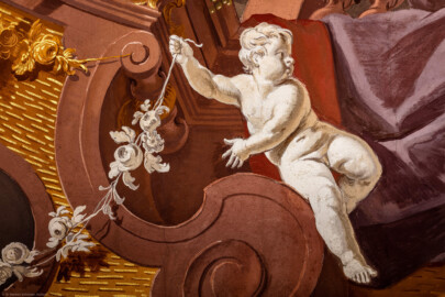 Schloss Bruchsal - Hauptbau / Corps de Logis - Beletage - Fürstensaal - Decke, äußere Zone, Südostecke - Ausschnitt aus der südöstlichen äußeren Zone - Scheinarchitektur mit Putto (Deckenfresko urspünglich gemalt 1751 von Johannes Zick, originalgetreu rekonstruiert 1966 bis 1969 von Wolfram Köberl) (aufgenommen im Mai 2020, am späten Vormittag)