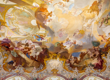 Schloss Bruchsal - Hauptbau / Corps de Logis - Von innen - Beletage - Marmorsaal / Kaisersaal - Decke, westliche Hälfte - Von Osten - Blick nach oben auf das westliche Deckenfresko - Oben ganz links: Darstellung einer Scheinarchitektur und des Ewigen Herdfeuers im Tempel der Vesta; oben ganz rechts: Darstellung des Weltbaumeisters Demogorgon mit Schlangenring und des Ewige Göttermahl im Olymp; oben Mitte: Darstellung eines Himmels mit verschiedenen Göttern und den Vier Elementen; unten links: Darstellung des Zeitgotts Chronos und des des Titans Atlas; unten rechts: Darstellung der Eitelkeit als Satyr, umgeben von weiteren Satyrn (Deckenfresko urspünglich gemalt 1754 von Johannes Zick, originalgetreu rekonstruiert 1971 bis 1974 von Wolfram Köberl; Stuck urspünglich von Johann Michael Feuchtmayer dem Jüngeren, rekonstruiert 1962 bis 1969 von Jakob und Josef Schnitzer) (aufgenommen im Juli 2020, um die Mittagszeit) Schloss Bruchsal - Hauptbau / Corps de Logis - Von innen - Beletage - Marmorsaal / Kaisersaal - Decke, westliche Hälfte - Von Osten - Blick nach oben auf das westliche Deckenfresko - Oben ganz links: Darstellung einer Scheinarchitektur und des Ewigen Herdfeuers im Tempel der Vesta; oben ganz rechts: Darstellung des Weltbaumeisters Demogorgon mit Schlangenring und des Ewige Göttermahl im Olymp; oben Mitte: Darstellung eines Himmels mit verschiedenen Göttern und den Vier Elementen; unten links: Darstellung des Zeitgotts Chronos und des des Titans Atlas; unten rechts: Darstellung der Eitelkeit als Satyr, umgeben von weiteren Satyrn (Deckenfresko urspünglich gemalt 1754 von Johannes Zick, originalgetreu rekonstruiert 1971 bis 1974 von Wolfram Köberl; Stuck urspünglich von Johann Michael Feuchtmayer dem Jüngeren, rekonstruiert 1962 bis 1969 von Jakob und Josef Schnitzer) (aufgenommen im Juli 2020, um die Mittagszeit)