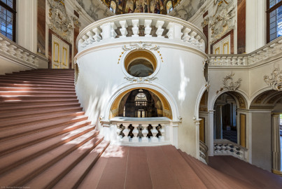 Schloss Bruchsal - Hauptbau / Corps de Logis - Treppenhaus / Kuppelsaal - Von Süden - Blick vom mittleren Treppenpodest der südlichen Treppe nach Norden auf die Treppe, den ovalen Kern des Treppenhauses, in die Grotte und in die Kuppel hinauf; links oben die Tür zum Marmorsaal / Kaisersaal, rechts oben die Tür zum Fürstensaal, rechts unten die Eingangshalle / Intrada (Treppenhaus und Treppe entworfen von Balthasar Neumann um 1731) (aufgenommen im Juli 2020, am frühen Nachmittag) Schloss Bruchsal - Hauptbau / Corps de Logis - Treppenhaus / Kuppelsaal - Von Süden - Blick vom mittleren Treppenpodest der südlichen Treppe nach Norden auf die Treppe, den ovalen Kern des Treppenhauses, in die Grotte und in die Kuppel hinauf; links oben die Tür zum Marmorsaal / Kaisersaal, rechts oben die Tür zum Fürstensaal, rechts unten die Eingangshalle / Intrada (Treppenhaus und Treppe entworfen von Balthasar Neumann um 1731) (aufgenommen im Juli 2020, am frühen Nachmittag)