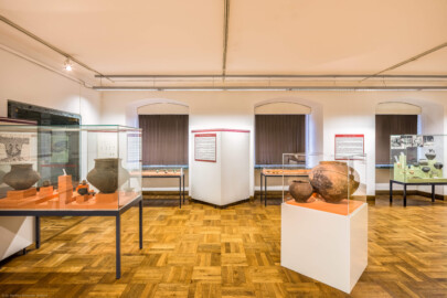 Städtisches Museum Bruchsal - Schloss Bruchsal - Hauptbau / Corps de Logis - Von innen - Südlicher Raum, Bereiche Bronze- / Hallstatt- / Römerzeit - Von Norden - Blick auf Vitrinen und Tafeln zur Bronze- / Hallstatt- / Römerzeit ; vorne links Kermaikgefäße aus einem Urnengrab der Bronzezeit, vorne rechts Kermaikgefäße aus der Hallstattzeit, hinten links Schmuck aus Frauengräbern aus der Bronzezeit, hinten Mitte Waffen und Schmuck aus der Bronzezeit, hinten rechts Keramik und Kleinfunde aus dem römischen Kastell Wagbach (aufgenommen im Dezember 2020, am Nachmittag) Städtisches Museum Bruchsal - Schloss Bruchsal - Hauptbau / Corps de Logis - Von innen - Südlicher Raum, Bereiche Bronze- / Hallstatt- / Römerzeit - Von Norden - Blick auf Vitrinen und Tafeln zur Bronze- / Hallstatt- / Römerzeit ; vorne links Kermaikgefäße aus einem Urnengrab der Bronzezeit, vorne rechts Kermaikgefäße aus der Hallstattzeit, hinten links Schmuck aus Frauengräbern aus der Bronzezeit, hinten Mitte Waffen und Schmuck aus der Bronzezeit, hinten rechts Keramik und Kleinfunde aus dem römischen Kastell Wagbach (aufgenommen im Dezember 2020, am Nachmittag)