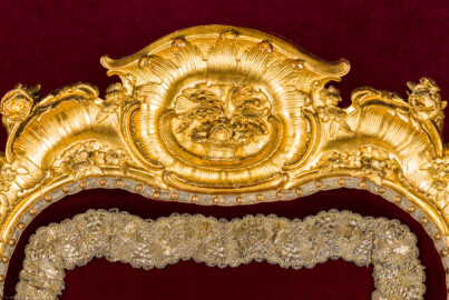 Schloss Bruchsal - Hauptbau / Corps de Logis - Von Innen - Beletage - Thronsaal - Südliche Wand, Mitte, Thronensemble - Blick auf die Lehnenbekrönung des Thronsessels (Armsessel um 1752-1758, geschnitzt vermutlich von Ferdinand Hundt; Höhe x Breite x Tiefe: 124 cm x 84 cm x 62 cm) (aufgenommen im Januar 2021, am frühen Nachmittag)