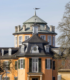 Waghäusel - Eremitage - Von Außen / Von Osten - Blick von der östlichen Friedrich-Hecker-Allee auf den Zentralbau mit dem Altan, der Uhr, dem Glockentürmchen, der Kuppel  und dem Zeltdach (aufgenommen im Februar 2021, um die Mittagszeit)