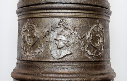 Schloss Bruchsal - Hauptbau / Corps de Logis - Von innen - Beletage - Winterspeisezimmer - Westseite, Mitte - Blick auf das unterste Segment des Stubenofens aus Gusseisen (sog. Kanonenofen) (beschädigt beim Brand 1945, wohl nach 2000 wiederhergestellt, u.a. durch Restauratorin Magdalena Baur und der Kunstschmiede Peter Klink aus Pfullendorf) (aufgenommen im März 2021, am frühen Nachmittag) Schloss Bruchsal - Hauptbau / Corps de Logis - Von innen - Beletage - Winterspeisezimmer - Westseite, Mitte - Blick auf das unterste Segment des Stubenofens aus Gusseisen (sog. Kanonenofen) (beschädigt beim Brand 1945, wohl nach 2000 wiederhergestellt, u.a. durch Restauratorin Magdalena Baur und der Kunstschmiede Peter Klink aus Pfullendorf) (aufgenommen im März 2021, am frühen Nachmittag)