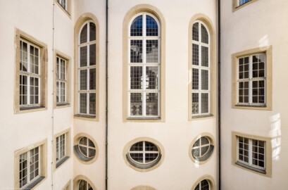 Schloss Bruchsal - Hauptbau / Corps de Logis - Von innen - Nördlicher Innenhof - Blick vom nördlichen Dienergang der Beletage nach Süden auf das Haupttreppenhaus, oben die drei hohen Bogenfenster des Kuppelsaals, unterhalb der Mitte die drei Ovalfenster der Haupttreppe, ganz unten die Fenster der Grotte (aufgenommen im März 2021, am späten Vormittag) Schloss Bruchsal - Hauptbau / Corps de Logis - Von innen - Nördlicher Innenhof - Blick vom nördlichen Dienergang der Beletage nach Süden auf das Haupttreppenhaus, oben die drei hohen Bogenfenster des Kuppelsaals, unterhalb der Mitte die drei Ovalfenster der Haupttreppe, ganz unten die Fenster der Grotte (aufgenommen im März 2021, am späten Vormittag)
