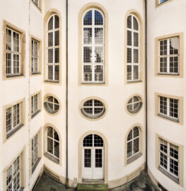 Schloss Bruchsal - Hauptbau / Corps de Logis - Von innen - Nördlicher Innenhof - Blick vom nördlichen Dienergang der Beletage nach Süden auf das Haupttreppenhaus, oben die drei hohen Bogenfenster des Kuppelsaals, in der Mitte die drei Ovalfenster der Haupttreppe, unten die Tür zur Grotte (aufgenommen im März 2021, um die Mittagszeit) Schloss Bruchsal - Hauptbau / Corps de Logis - Von innen - Nördlicher Innenhof - Blick vom nördlichen Dienergang der Beletage nach Süden auf das Haupttreppenhaus, oben die drei hohen Bogenfenster des Kuppelsaals, in der Mitte die drei Ovalfenster der Haupttreppe, unten die Tür zur Grotte (aufgenommen im März 2021, um die Mittagszeit)