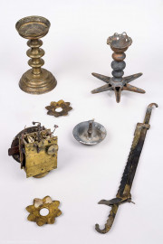 Städtisches Museum Bruchsal - Schloss Bruchsal - Hauptbau / Corps de Logis - Magazin - Jüdische Kultgeräte, teils aus Bronze; oben rechts und Mitte eine Sabbatampel mit sechsstrahligem Lichterstern und Öl-Auffangschale, vermutlich aus privatem Haushalt, möglicherweise aus der Bruchsaler Huttenstraße; unten rechts eine verstellbare Aufhängung für eine Sabbat-Lampe in Form einer Säge mit Haken an den Enden, oben links ein einarmiger Kerzenhalter für Stumpenkerze, Mitte links und unten links zwei Wachsauffänger, alle vier Geräte möglicherweise aus der ehemaligen Synagoge Bruchsal; links unterhalb der Mitte ein beschädigtes Uhrwerk mit der Inschrift "* I * Könner * A * Bruchsall *" (Inv.Nr. 39.108) (aufgenommen im April 2021, am Nachmittag) Städtisches Museum Bruchsal - Schloss Bruchsal - Hauptbau / Corps de Logis - Magazin - Jüdische Kultgeräte, teils aus Bronze; oben rechts und Mitte eine Sabbatampel mit sechsstrahligem Lichterstern und Öl-Auffangschale, vermutlich aus privatem Haushalt, möglicherweise aus der Bruchsaler Huttenstraße; unten rechts eine verstellbare Aufhängung für eine Sabbat-Lampe in Form einer Säge mit Haken an den Enden, oben links ein einarmiger Kerzenhalter für Stumpenkerze, Mitte links und unten links zwei Wachsauffänger, alle vier Geräte möglicherweise aus der ehemaligen Synagoge Bruchsal; links unterhalb der Mitte ein beschädigtes Uhrwerk mit der Inschrift "* I * Könner * A * Bruchsall *" (Inv.Nr. 39.108) (aufgenommen im April 2021, am Nachmittag)