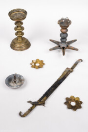 Städtisches Museum Bruchsal - Schloss Bruchsal - Hauptbau / Corps de Logis - Magazin - Jüdische Kultgeräte, teils aus Bronze; oben rechts und unten links eine Sabbatampel mit sechsstrahligem Lichterstern und Öl-Auffangschale, vermutlich aus privatem Haushalt, möglicherweise aus der Bruchsaler Huttenstraße; unten Mitte eine verstellbare Aufhängung für eine Sabbat-Lampe in Form einer Säge mit Haken an den Enden, oben links ein einarmiger Kerzenhalter für Stumpenkerze, Mitte und unten rechts zwei Wachsauffänger, alle vier Geräte möglicherweise aus der ehemaligen Synagoge Bruchsal  (Inv.Nr. 39.108) (aufgenommen im April 2021, am Nachmittag)