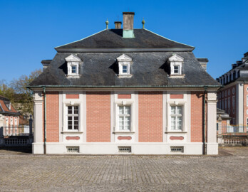 Schloss Bruchsal - Hofkontrollamt - Von Westen - Blick nach Osten auf die Westseite des Hofkontrollamts, links im Hintergrund der nördliche Remisenbau, rechts das Zeughaus, ganz rechts der Kanzleibau (aufgenommen im April 2021, am späten Nachmittag)