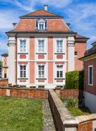 Schloss Bruchsal - Kommandantenwohnung - Von Süden - Blick vom Vorplatz des Kanzleibaus nach Norden auf die Südfassade der Kommandantenwohnung, links das Damianstor, rechts das Zeughaus (aufgenommen im Mai 2021, am Nachmittag)