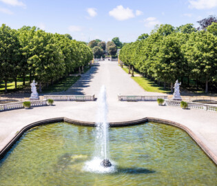 Schloss Bruchsal - Schlossterrasse / Schlossgarten - Blick vom westlichen Balkon auf die Mitte der Schlossterrasse, auf die Allee sowie auf die Kastanienbäumen des Schlossgartens (aufgenommen im Mai 2021, am Nachmittag)