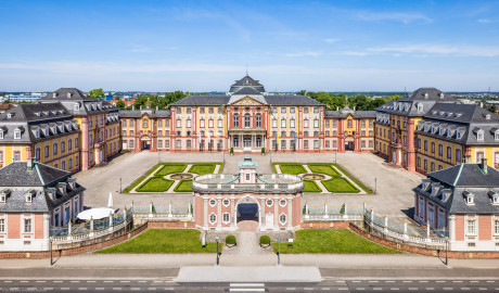 Schloss Bruchsal - Zentrum der Schlossanlage - Von Außen - Von Osten / Von oben - Blick von der Plattform des Kanzleibaus nach unten auf die Dreiflügelanlage; in der Mitte der Hauptbau / das Corps de Logis, links der Mitte der südliche Verbindungsbau, links davon der Kirchenflügel / die Hofkirche / St. Damian und Hugo, rechts der Mitte der nördliche Verbindungsbau, rechts davon der Kammerflügel / das Amtsgericht; vorne links das Hofzahlamt (heute Schlosscafé), vorne in der Mitte das Torwachtgebäude, vorne rechts das Hofkontrollamt; in der Mitte der Anlage der Ehrenhof (aufgenommen im Juni 2021, am späten Vormittag) Schloss Bruchsal - Zentrum der Schlossanlage - Von Außen - Von Osten / Von oben - Blick von der Plattform des Kanzleibaus nach unten auf die Dreiflügelanlage; in der Mitte der Hauptbau / das Corps de Logis, links der Mitte der südliche Verbindungsbau, links davon der Kirchenflügel / die Hofkirche / St. Damian und Hugo, rechts der Mitte der nördliche Verbindungsbau, rechts davon der Kammerflügel / das Amtsgericht; vorne links das Hofzahlamt (heute Schlosscafé), vorne in der Mitte das Torwachtgebäude, vorne rechts das Hofkontrollamt; in der Mitte der Anlage der Ehrenhof (aufgenommen im Juni 2021, am späten Vormittag)