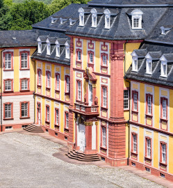 Schloss Bruchsal - Kammerflügel / Amtsgericht - Von Außen - Von Südost - Blick von der Plattform des Kanzleibaus nach unten auf den Mittelrisalit des Kammerflügels / des Amtsgerichts (aufgenommen im Juni 2021, um die Mittagszeit) Schloss Bruchsal - Kammerflügel / Amtsgericht - Von Außen - Von Südost - Blick von der Plattform des Kanzleibaus nach unten auf den Mittelrisalit des Kammerflügels / des Amtsgerichts (aufgenommen im Juni 2021, um die Mittagszeit)