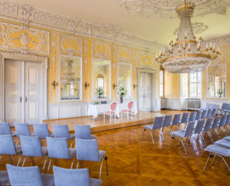 Schloss Bruchsal - Kammerflügel / Amtsgericht - Kammermusiksaal - Von Südost - Blick in den Raum, ausgestattet für standesamtliche Trauungen mit einem Tisch für das Brautpaar und den Standesbeamten (Saal ursprünglich gestaltet von Joachim Günther; heute genutzt für Trauungen und die Bruchsaler Schlosskonzerte) (aufgenommen im Juli 2021, am späten Vormittag)