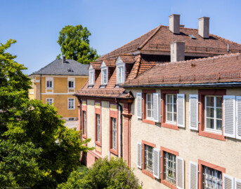 Schloss Bruchsal - Hofapotheke / Hofsattlerei - Von außen - Von Osten - Blick von der neuzeitlichen Mesnerswohnung im 1. Obergeschoss des Kirchturms nach Westen auf die Südseite der ehemaligen Hofsattlerei (rechts) und der ehemaligen Hofapotheke (Mitte) sowie auf die Ostseite der Südlichen Orangerie (hinten) (aufgenommen im Juli 2021, am Nachmittag)